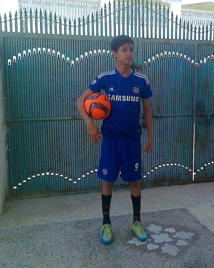 Teenage Daud in a Chelsea kit holding an orange football